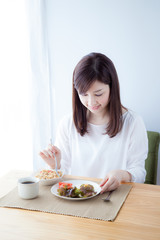 Obraz na płótnie Canvas 朝食を食べる女性　野菜