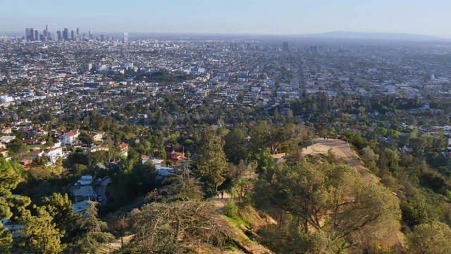 An establishing shot of the Los Angeles skyline as seen from Griffith Observatory as hikers walk the trails below.  	