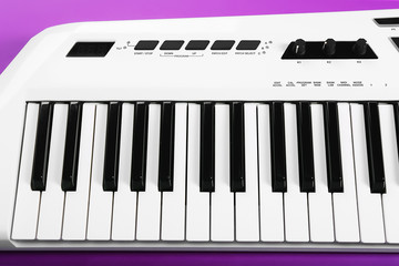 Keyboard of synthesizer on purple background