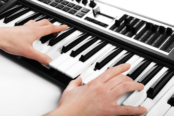 Obraz na płótnie Canvas Male hand playing of synthesizer closeup