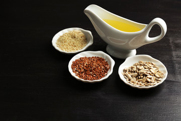 Different kinds of seeds and oil on wooden table