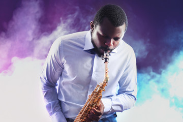 Fototapeta na wymiar African American jazz musician playing the saxophone against colorful smoky background