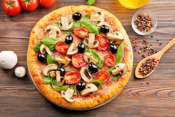 Delicious tasty pizza with ingredients on wooden table