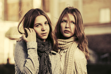 Two young fashion teen girls oo city street