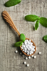Analogue of sugar cubes and stevia  on grey wooden background
