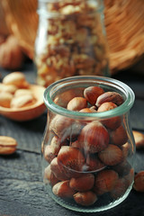 Mix of nuts in the glass jars and wooden spoon, on the table