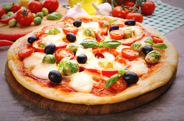Delicious pizza with cheese and vegetables on wooden table closeup