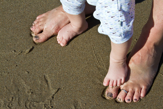 Baby & Mom's feet on beach with sand