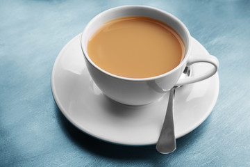 Porcelain cup of tea with milk on gray background