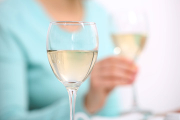 Dinner with glasses of wine on light blurred background