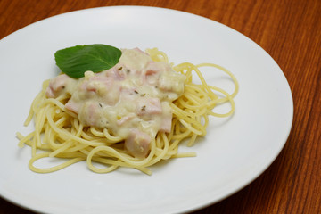 spaghetti white cream sauce and basil leafe
