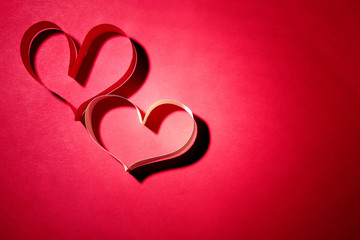 Valentine's Day heart made of ribbon on red background