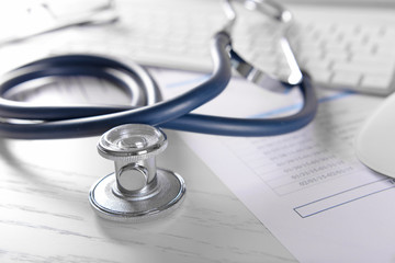 Cardiogram chart with medical stethoscope on table closeup