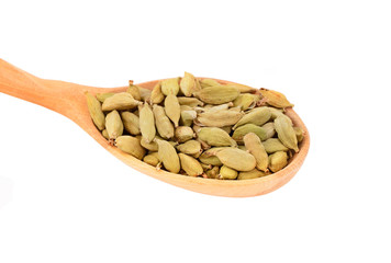 Cardamom pods in wooden spoon