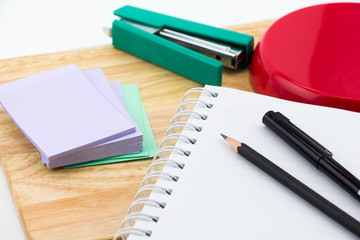Notebook, note paper and black pencil on writing table