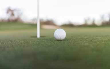  Golf ball close to cup of hole on putting green