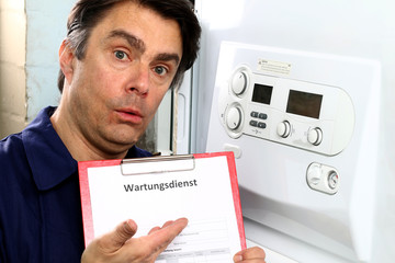 Handwerker zeigt auf Wartungsvertrag von Heizkessel