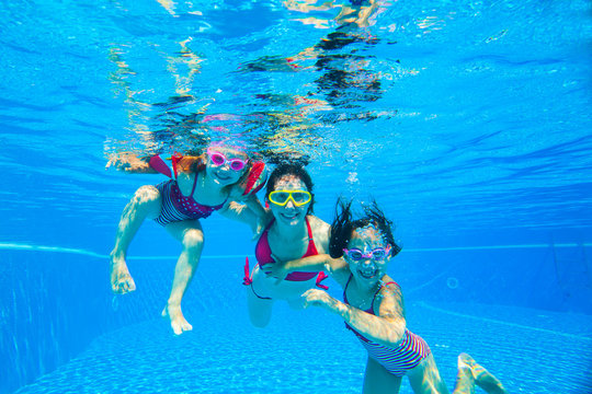 girls with mother playing  underwater