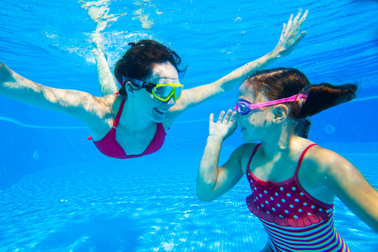girl with mother playing  underwater