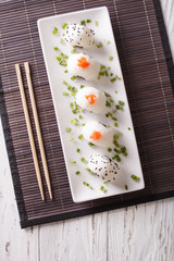 Obraz na płótnie Canvas Japanese food onigiri rice balls on a plate. Vertical top view 