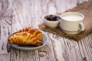 Croissant,milk and cherry jam. Breakfast concept