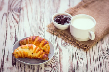 Croissant,milk and cherry jam. Breakfast concept