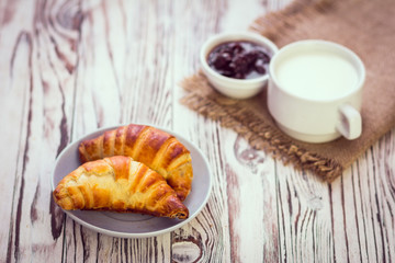 Croissant,milk and cherry jam. Breakfast concept