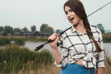  country lady standing against pond on ranch with fish-rod