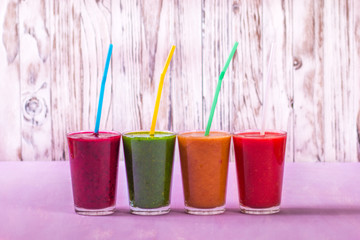 glasses of various smoothies with straws for healthy dieting breakfast