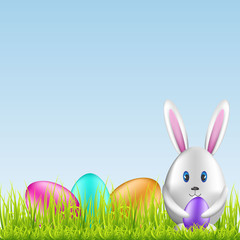 Easter bunny and colorful eggs on spring medow