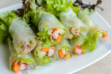 spring rolls with fresh vegetable on wooden table