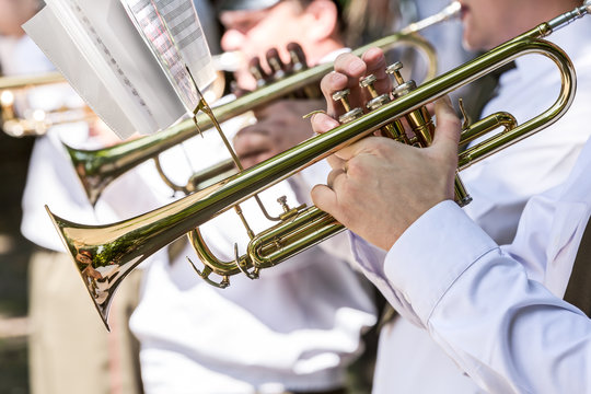 military musicians playing gold trumpets on music festival