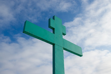 Green Orthodox cross on a background of blue sky