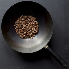 Fragrant fried coffee beans on a metal pan. Close up, top view