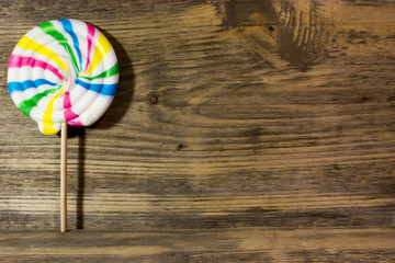 Round spiral color candy on wooden background.