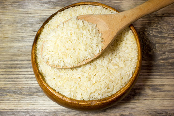 Fototapeta na wymiar Grains of rice in wooden plate