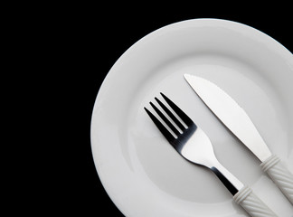 Part of Knife fork and plate on a black background