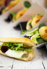 Sandwich with salad on wooden table