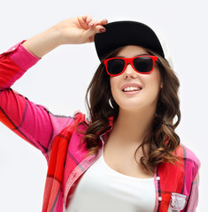 Beautiful girl laughing, wearing cap and sunglasses