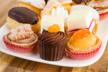 Colourful mini cakes tray on wood