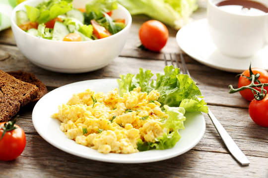 Scrambled eggs with vegetables on a grey wooden table