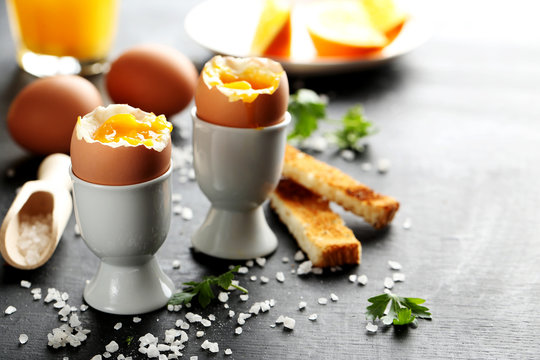 Boiled egg with toasts on a black wooden table