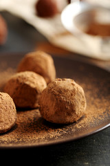 Fototapeta na wymiar Sweet chocolate truffle on a black wooden table