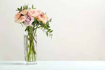 Bouquet of beautiful roses on a blue wooden table