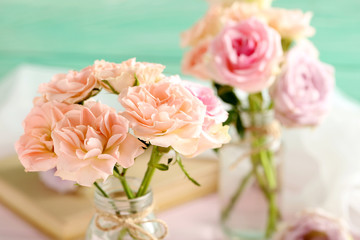 Bouquet of beautiful roses on a pink wooden table