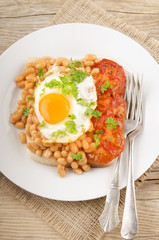 fried egg with grilled tomato slices and baked beans