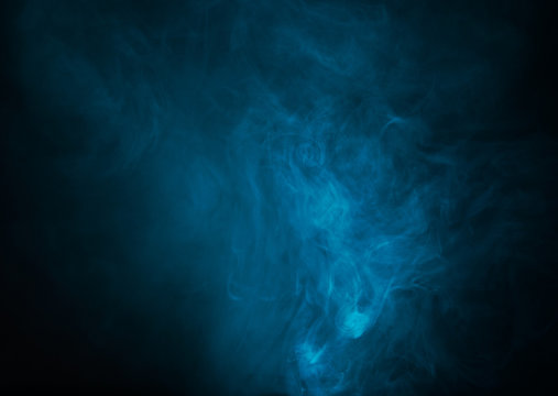 Blue smoke over black studio background