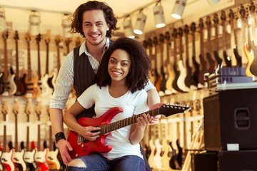 Couple playing electric guitar