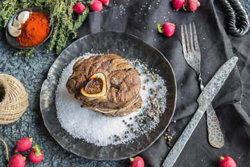 Steak on a metal plate with salt and pepper,garlic