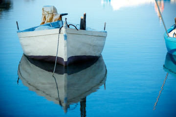 Boat on lake with a reflection in the water at sunrise